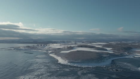 Aerial-View-Waves-Breaking-Against-Winter-Snow-Shore-Of-Hokkaido
