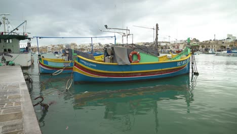 Barcos-Pesqueros-Malteses-Multicolores-Meciéndose-En-La-Superficie-Del-Agua-En-La-Bahía-De-Marsaxlokk-En-Invierno