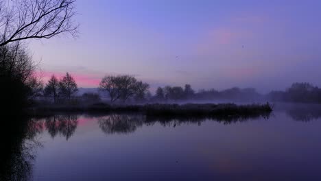 Static-shot-of-colorful-and-foggy-Nunnery-Lake-at-sunrise-in-Thetford,-Norfolk,-UK