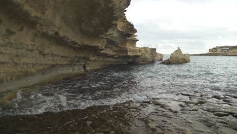 Las-Olas-Del-Mar-Mediterráneo-Enjuagan-La-Pared-De-Piedra-Caliza-De-La-Playa-De-Il-kalanka-En-Malta