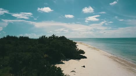 Gorgeous-slowly-sinking-down-drone-shot-of-a-empty-paradise-dream-beach-at-midday-noon-time