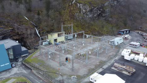 Electric-high-voltage-transformer-and-distribution-station-outside-hydroelectric-powerplant-at-Dalekvam-Norway---BKK-Eviny-company---orbiting-aerial