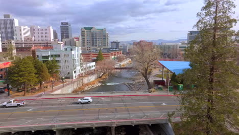 Pull-away-from-overpass-in-downtown-Reno-and-over-Truckee-River-and-urban-park-on-a-pretty-winter-day-in-Nevada