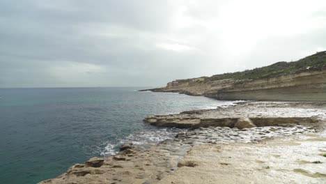 Seichtes-Wasser-Umspült-Das-Ufer-Des-Steinstrandes-Il-kalanka-In-Malta