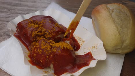 Comer-Auténtica-Salchicha-Currywurst-Alemana-Con-Un-Pico-De-Madera
