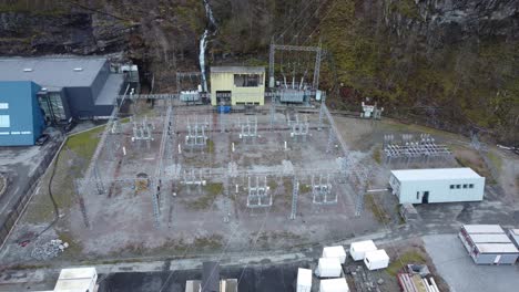 High-voltage-electric-transformer-station-and-distribution-central-in-Dalekvam-Norway---ascending-aerial-with-tilt-down-above-facilities