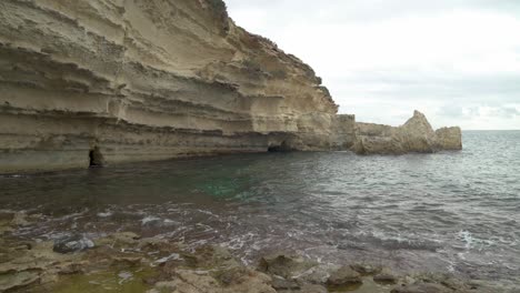 Mar-Mediterráneo-Tranquilo-Cerca-De-La-Pared-De-Piedra-Caliza-De-La-Playa-De-Il-kalanka-En-Malta