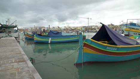 Traditional-Maltese-Fishing-Boats-Rocking-on-Surface-of-Water-in-Marsaxlokk-Bay-in-Winter
