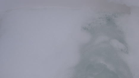 Blowing-bubble-bath-foam-in-bath