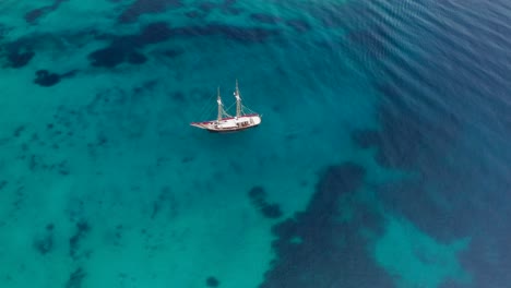 Old-wood-sailboat-who-arrives-in-a-bay-to-drop-anchor