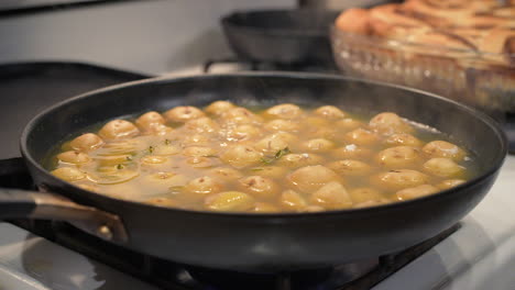 A-hot-iron-skillet-on-the-stove-full-of-potatoes-simmering-and-steaming-in-slow-motion