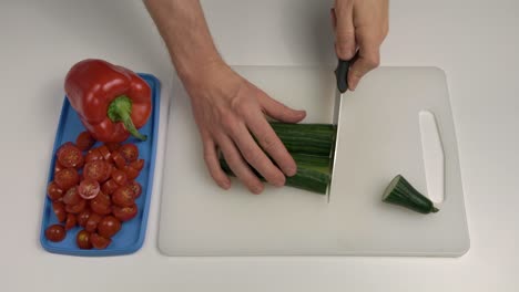 Man-cutting-cucumber-with-knife