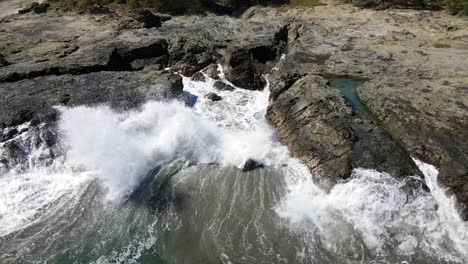 Felsige-Steinküste-Mit-Wellen,-Die-Gegen-Die-Steine-Spritzen-Drohnenaufnahme-In-Costa-Rica-Gefilmt