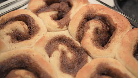 Golden-brown-cinnamon-rolls-fresh-from-the-oven---isolated-close-up-overhead-motion