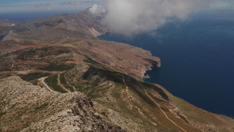 Beautiful-landscape-drone-shot-of-in-Greece-on-a-rocky-peak,-Amorgos-Island-in-cyclades-Aegean-Sea-with-beautiful-panorama-of-blue-ocean-and-mountains