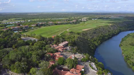 Aerial-flyover-Casa-de-Campo-Village-with-Golf-Resort-beside-Chavon-River-on-Dominican-Republic-Island-during-summer