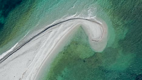 Beautiful-drone-shot-of-sandbank-like-a-comma-in-green-gradient-sea,-Amorgos,-Cyclades-Island-in-Greece