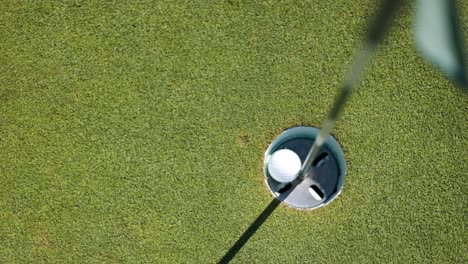Top-down-shot-of-golf-ball-falling-into-the-hole
