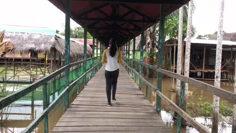 Peruanisches-Mädchen,-Das-Durch-Eine-Brücke-In-Einer-Dschungelstadt-Geht