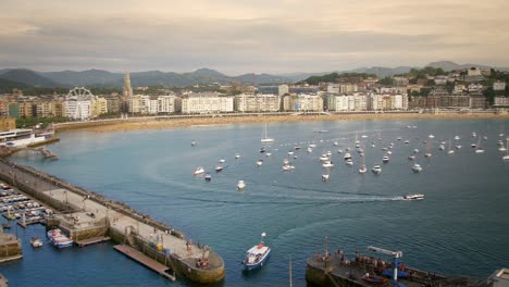 Boats-on-a-calm-harbor-during-sunset-on-a-bright-sunny-day-in-San-Sebastian-Spain-Europe,-panning-shot