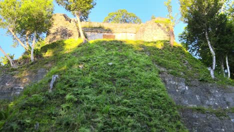 Nakum-Guatemala,-old-mayan-ruin-in-the-jungle,-archeological-site,-rotted-pyramids-covered-by-grass