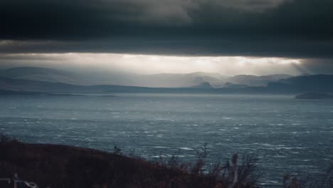 Ein-Zeitraffer-Von-Sonnenstrahlen-Durchdringt-Die-Dicke-Graue-Wolkendecke-über-Dem-Fjord