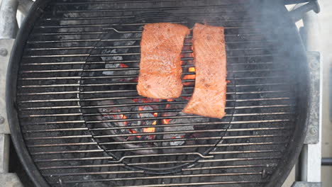 Placing-marinated-salmon-fillets-on-the-hot-barbecue-to-sear-in-the-flavor---overhead-view