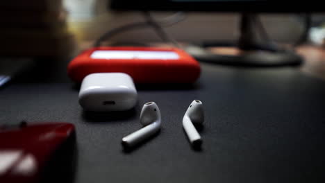 Airpods-stacked-next-to-hard-drive-backups-at-editing-desk