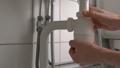 Mann-Entfernt-Geruchsverschluss-Unter-Dem-Waschbecken-Im-Badezimmer