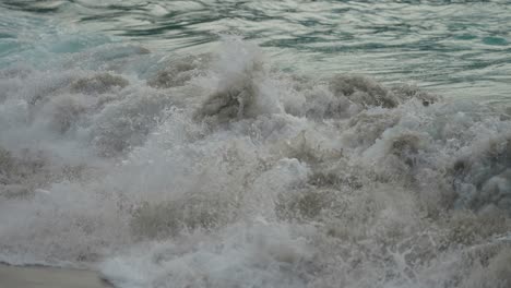 Waves-crashing-on-the-sandy-beach.-Close-up,-slow-motion