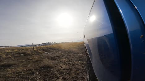 Driving-off-road-through-the-dirt-and-mud-in-a-truck---rear-view-in-slow-motion