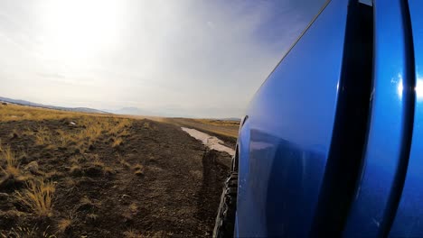 Driving-on-an-off-road-trail-with-mud-and-snow-flying-off-the-truck-wheels---rear-view-in-slow-motion