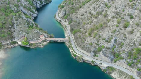 Drone-view-of-bridge-over-the-beautiful-Lago-di-San-domenico-Lake-in-Abruzzo,-ITALY