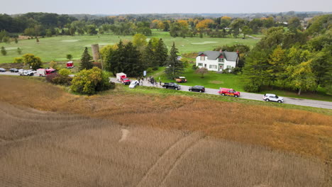 Car-Traffic-Accident-Incident-Site-at-Countryside-Road,-First-Aid-Vehicles-Fire-Trucks-and-Stationary-cars-along-the-Street-Roadside,-Green-Fields-and-Agricultural-Lands-around,-Aerial-View