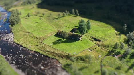 An-aerial-view-of-a-traditional-sod-roof-cabin-on-the-river-bank