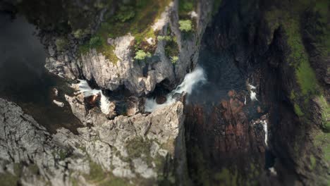 Aerial-view-of-the-massive-waterfall-falling-into-a-deep-rocky-canyon