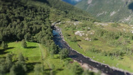 Aerial-view-of-the-river-flowing-through-the-wide-rocky-valley