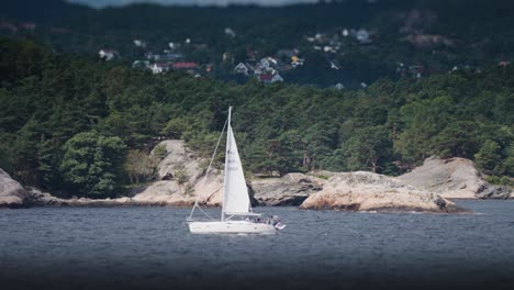 A-small-sailboat-battling-the-waves-between-the-rocky-islands