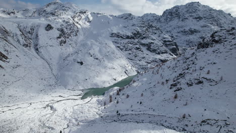 Fliegen-Sie-Im-Winter-An-Einem-Sonnigen-Tag,-Italien,-Von-Einer-Drohne-über-Das-Delta-Eines-Gletscherflusses-In-Den-Alpen