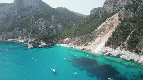Aerial-landscape-drone-video-of-tropical-paradise-turquoise-beach-and-sea-cliffs-in-the-mediterranean,-Cala-Goloritz?