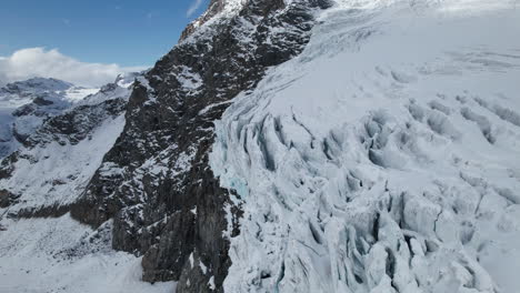 Drohnenlandschaftsblick-Auf-Die-Risse-Im-Gesicht-Eines-Großen-Gletschers-An-Einem-Sonnigen-Tag-Im-Winter-In-Den-Alpen