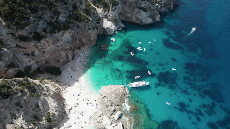 Aerial-top-down-drone-video-of-tropical-paradise-turquoise-coast-in-the-mediterranean,-Sardinia-with-boats