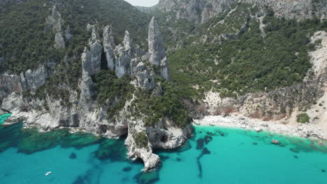 Aerial-drone-video-of-tropical-paradise-turquoise-beach-and-sea-cliffs-in-the-mediterranean,-Costa-Azzurra,-Sardinia