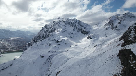 Fliegen-Sie-Im-Winter-An-Einem-Sonnigen-Tag,-Italien,-Von-Einer-Drohne-Aus-über-Majestätische-Berggipfel-In-Den-Alpen