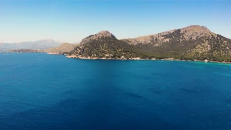 Drone-over-scenic-cerulean-waters-of-Mediterranean-towards-rugged-Majorca,-Spain