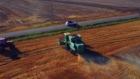 Combine-Tractor-Harvesting-Wheat-In-A-Field-In-Lithuania---drone-shot