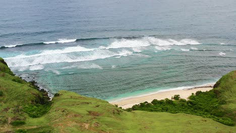 empty-white-sand-tropical-beach-at-Bukit-Merese-Lombok-with-turquoise-waves-crashing,-aerial