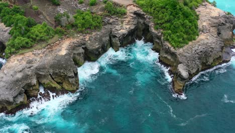 aerial-of-dangerous-tropical-coastline-with-turquoise-waves-crashing-on-sharp-rocks