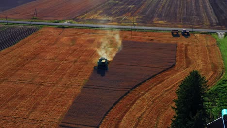 Aerial-View-Of-Combine-Harvesting-Crops-On-Golden-Wheat-Field-At-Daytime