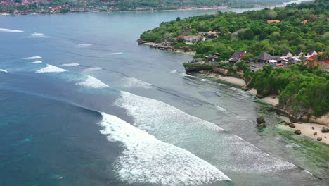 tropical-ocean-waves-crashing-at-Nusa-Ceningan-Island-coastline,-aerial-top-down